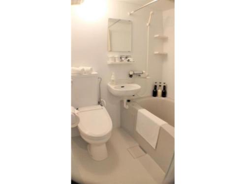 ein weißes Bad mit einem WC und einem Waschbecken in der Unterkunft BANDE HOTEL OSAKA - Vacation STAY 98144 in Osaka