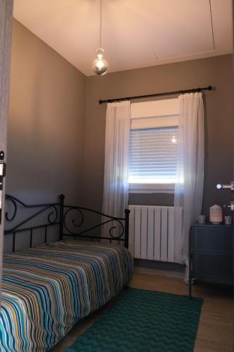 - une chambre avec un lit et une fenêtre avec des rideaux dans l'établissement Apartmani Jana 2, à Divčibare