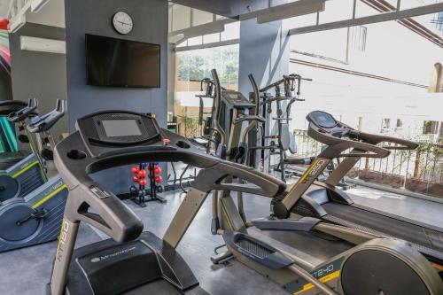 a gym with several cardio machines and a flat screen tv at Lindo Flat REFORMADO no coração da Vila Olimpia in Sao Paulo