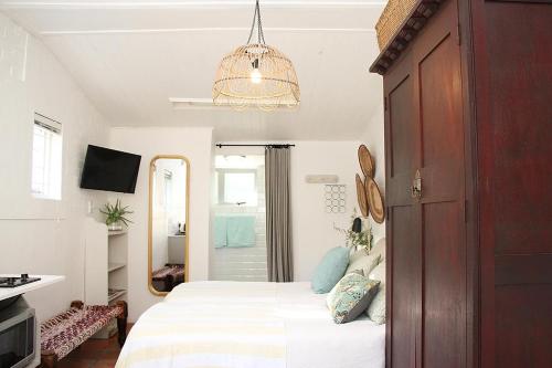 a bedroom with a bed and a chandelier at Courtyard Studios (with air conditioning) in Stellenbosch