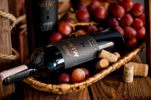 a basket with a bottle of wine and some apples at Castel Mimi Wine Resort in Bulboaca