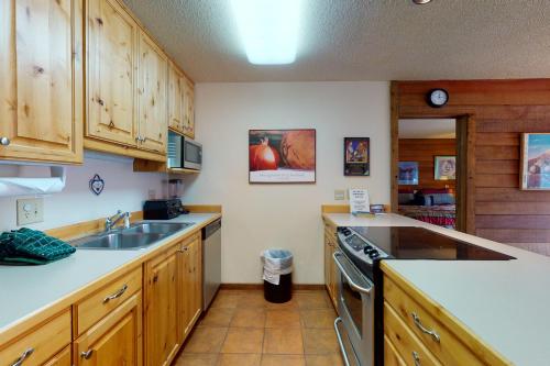 a kitchen with wooden cabinets and a sink at Anaconda 102 in Copper Mountain