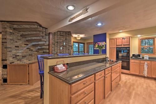 cocina grande con armarios de madera y pared de piedra en Spacious Lakehouse with Deck, Kayaks, and Dock!, en Cambridge