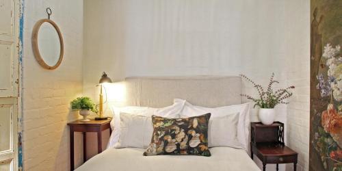 a bedroom with a bed with two pillows on it at Courtyard Studios (with air conditioning) in Stellenbosch