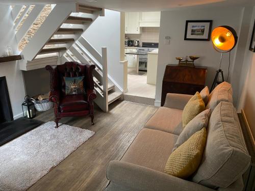 a living room with a couch and a staircase at Arthur Street Guest Cottage (Sister cottage number 3) in Hillsborough