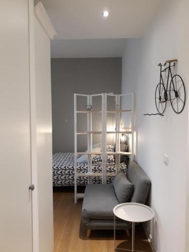 Cette chambre dispose d'un canapé et d'un lit avec un vélo. dans l'établissement ARTEMAR STUDIO "casavacanzevistamare", à Trieste