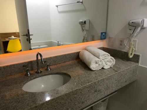 a bathroom counter with a sink and a mirror at Resort Granja Brasil Itaipava Piscinas aquecidas in Petrópolis