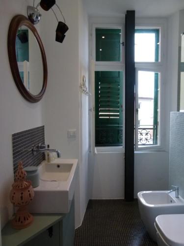 La salle de bains est pourvue d'un lavabo, d'un miroir et d'une fenêtre. dans l'établissement ARTEMAR STUDIO "casavacanzevistamare", à Trieste