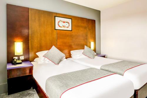 a bedroom with two beds and a wooden headboard at Best Western Sheffield City Hotel in Sheffield