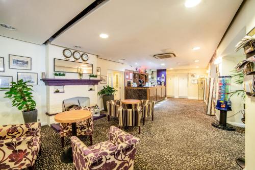 a lobby with chairs and tables and a bar at The Bridge House Hotel in Reigate
