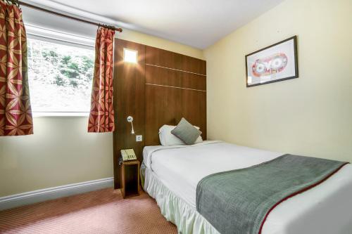 a hotel room with a bed and a window at The Bridge House Hotel in Reigate