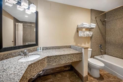 a bathroom with a sink and a toilet and a tub at Quality Inn & Suites Jacksonville-Baymeadows in Jacksonville