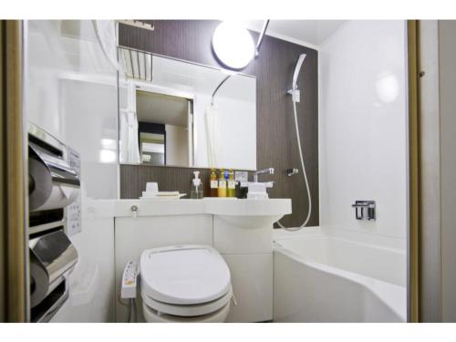 a bathroom with a toilet and a sink and a mirror at Kagoshima Plaza Hotel Tenmonkan - Vacation STAY 97872 in Kagoshima