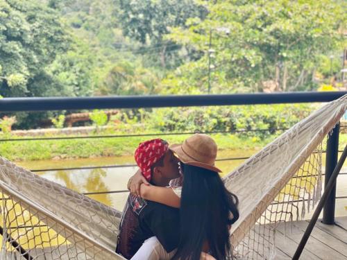 a man and a woman sitting on a bridge at Hotel Casas de Campo El Ciruelo in San Gil