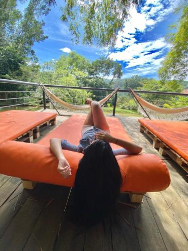 a person laying on a couch on a hammock at Hotel Casas de Campo El Ciruelo in San Gil