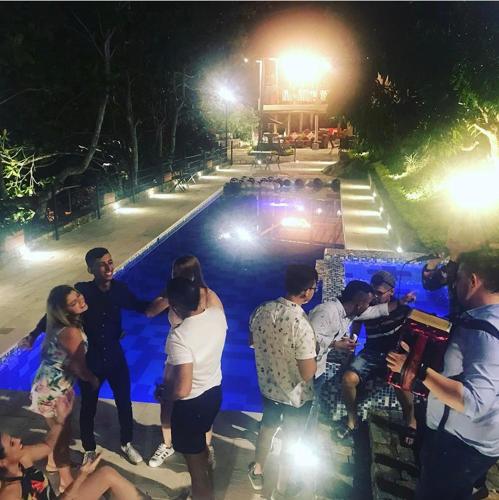 a group of people standing around a swimming pool at night at Hotel Casas de Campo El Ciruelo in San Gil