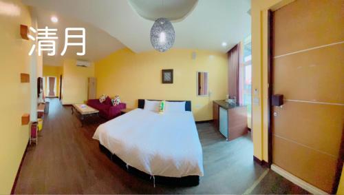 a bedroom with a bed and a living room at 月光冷泉民宿 in Hengchun