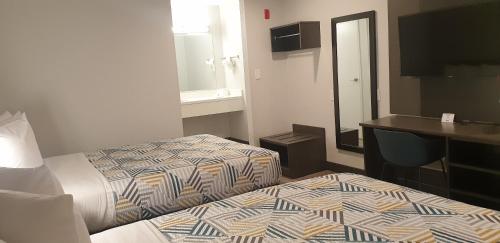a hotel room with two beds and a mirror at Motel 6-Bellflower, CA - Los Angeles in Bellflower