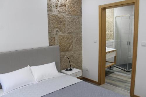 um quarto com uma cama e um banheiro com uma pia em ALOJAMENTO GIRASSOL - Guest House - Quarto com casa de banho privativa em Castelo Branco