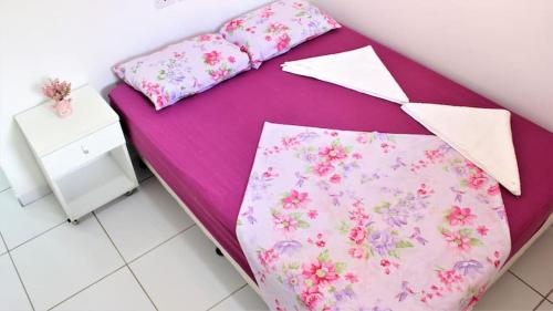 - un lit violet avec des draps et des oreillers roses dans l'établissement PRAIA RESIDENCE 303A - Porto de Galinhas - PE, à Porto de Galinhas
