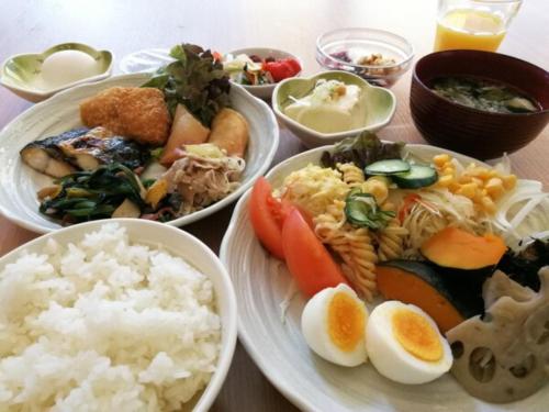 a table topped with plates of food and rice at Sky Heart Hotel Kawasaki - Vacation STAY 97877 in Kawasaki