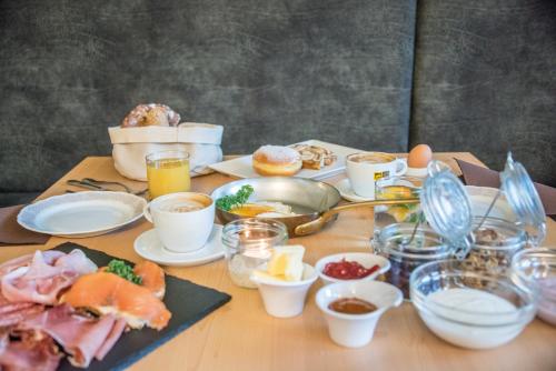 a table topped with plates of food and eggs at Apparthotel Feldhof - Living and Bistro in Nova Ponente