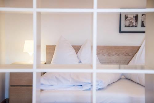 a bedroom with a bed with white pillows at Apparthotel Feldhof - Living and Bistro in Nova Ponente