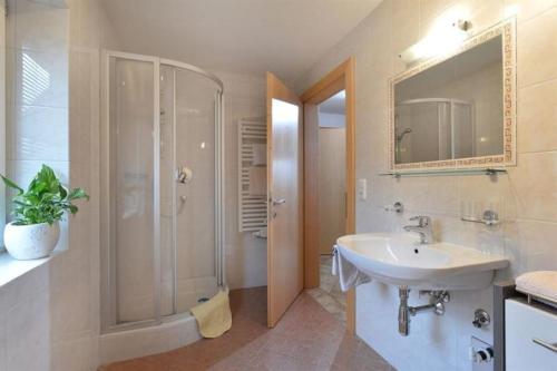 a bathroom with a sink and a shower and a mirror at Appartement Christine in Brixen im Thale