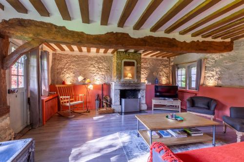 - un salon avec une table et une cheminée dans l'établissement Le Manoir du Perroy, à Saint-Wandrille-Rançon