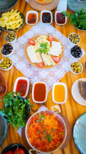 uma mesa de madeira coberta com pratos de comida e tigelas de comida em Abant Villa Otel em Bolu