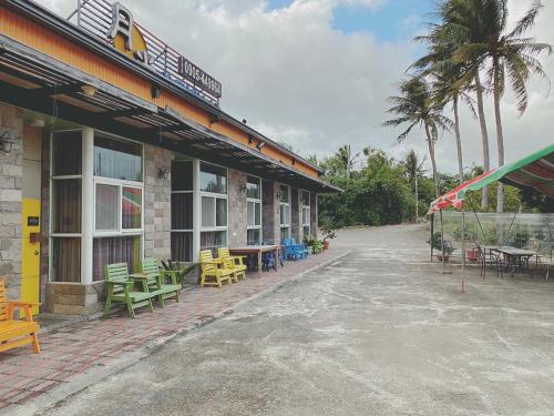 a building with tables and chairs in front of it at 月光冷泉民宿 in Hengchun