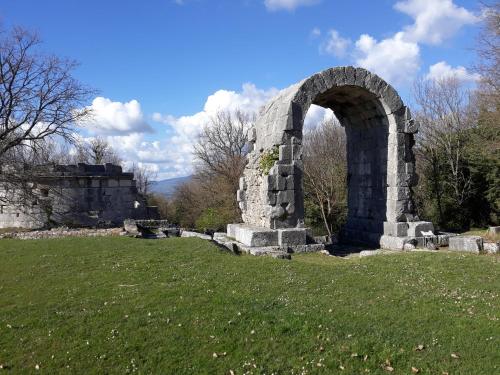 an old stone arch in a field of grass at La Casa Rosa in Terni