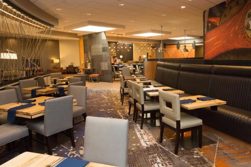 a dining room with wooden tables and chairs at DoubleTree by Hilton Dayton Fairborn in Fairborn
