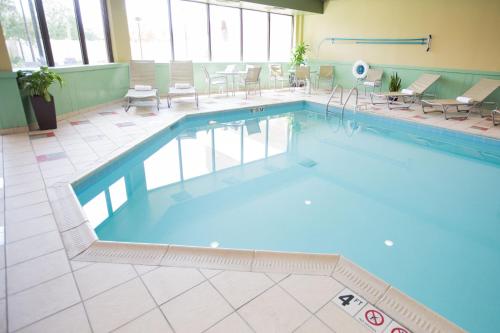 una gran piscina con sillas y mesas en un edificio en Holiday Inn Dayton/Fairborn I-675, an IHG Hotel en Fairborn