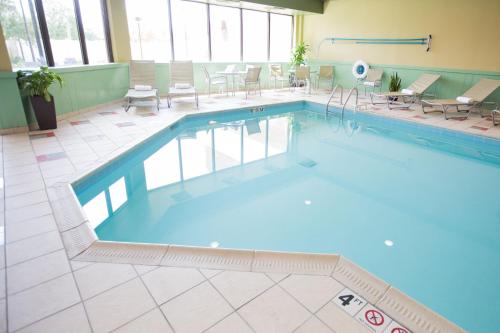 a large swimming pool with chairs and tables in a building at DoubleTree by Hilton Dayton Fairborn in Fairborn