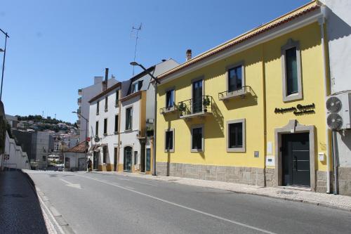um edifício amarelo no lado de uma rua em Alojamento Girassol em Castelo Branco