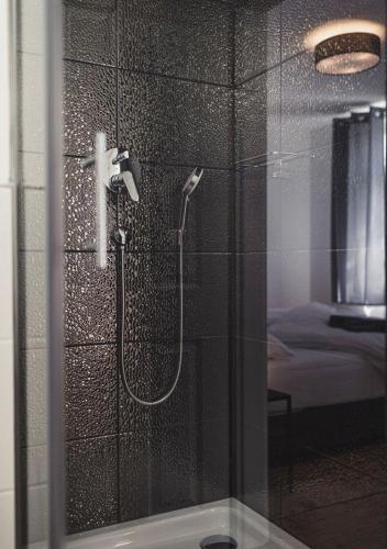 a shower in a bathroom with a glass door at Ferienwohnungen und Boardinghouse Heimbach in Lahr in Lahr