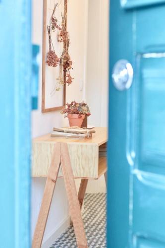a small wooden table in a kitchen next to a blue refrigerator at Casa do Arco - Beja in Beja