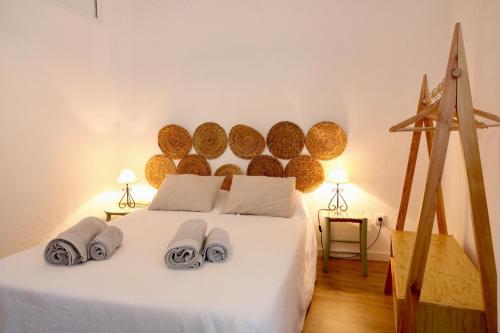 una camera da letto con un letto bianco e asciugamani di Casa do Arco - Beja a Beja
