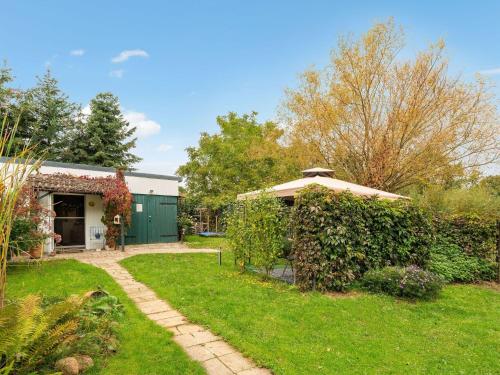 a garden with a green building and a green yard at Quaint Holiday Home near Forest in Stuer in Stuer