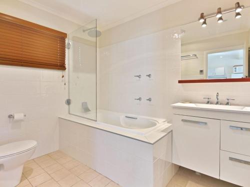 une salle de bains blanche avec toilettes et lavabo dans l'établissement Acacia Cottage at Hyams Beach, à Hyams Beach