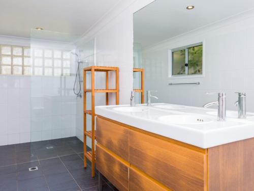 La salle de bains est pourvue d'un lavabo blanc et d'un miroir. dans l'établissement Bimbadgen at Hyams Beach, à Hyams Beach