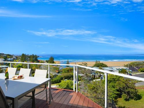 a balcony with a white table and chairs and the ocean at Jewel of Gerroa Gerroa in Gerroa