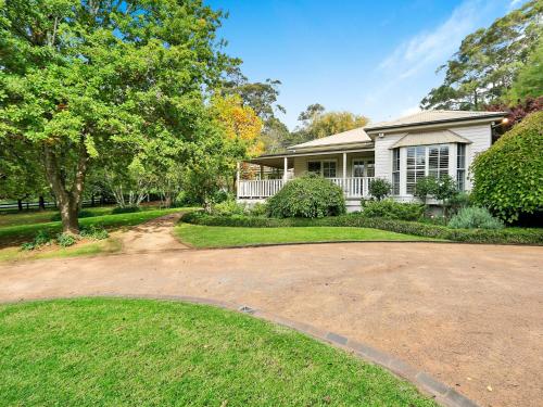 a house with a driveway in front of it at Mirrabooka Burrawang in Burrawang