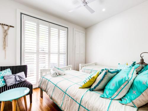 a bedroom with two beds and a window at Majestic on Palm Beach in Sanctuary Point