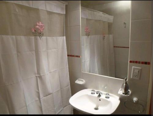 a white bathroom with a sink and a mirror at DEPARTAMENTO CALAFATE CENTRICO in El Calafate