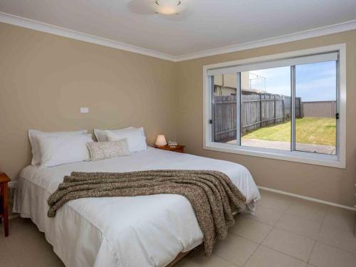 a bedroom with a large bed and a window at Peninsula 180 Gerroa in Gerroa