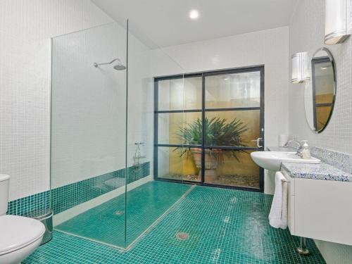 a bathroom with a shower and a toilet and a sink at Number Nine Gerroa in Gerroa