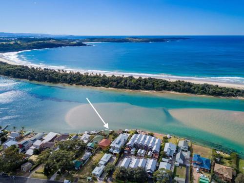 an aerial view of a beach with houses and the ocean at Riverside Cottage Minnamurra in Minnamurra