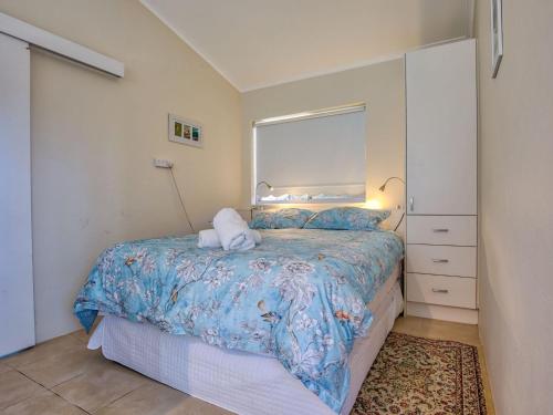 - une chambre avec un lit et une couette bleue dans l'établissement Riverside Studio Minnamurra, à Minnamurra